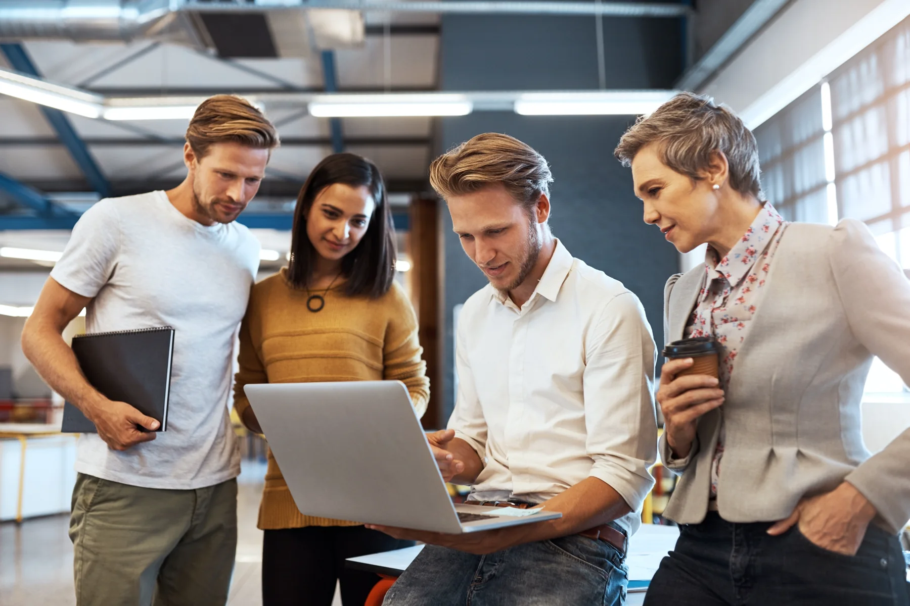 Business team planning website and marketing work around a laptop